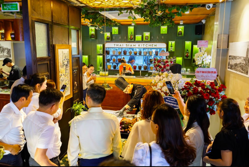 Không gian gỗ tối, tranh Thái và cấu trúc bàn ăn cũng hướng tới các nhóm khách và gia đình.