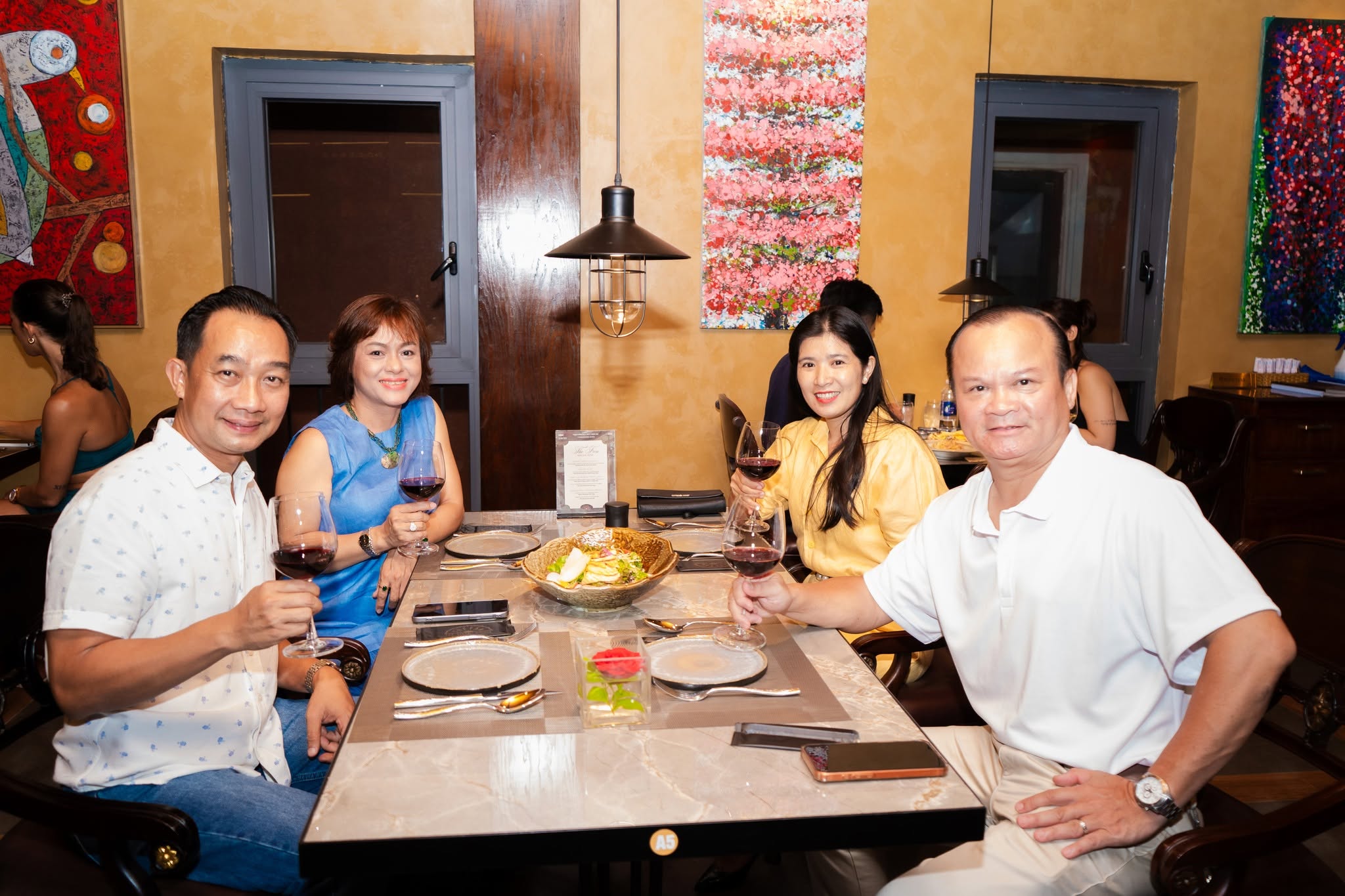 Một bàn bốn người nâng ly trong buổi tối khai trương Steakhouse The Fan